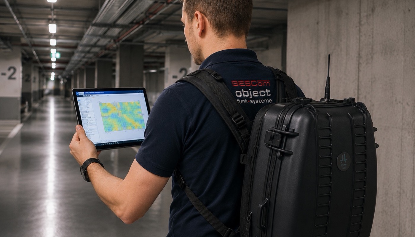 BESCom Techniker bei der Erforderlichkeitsmessung BOS-Funk im Gebäude mit Messkoffer und Tablet